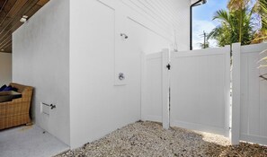 A white exterior wall with a door and a white fence. - Beautiful Beach house! Heated pool and spa! (Holmes Beach)