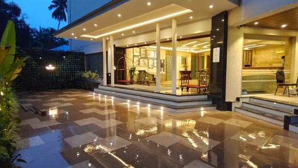 A modern hotel entrance with a covered outdoor area, a check-in desk, and a reception area. - MERITAS GRAND INN (Calangute)