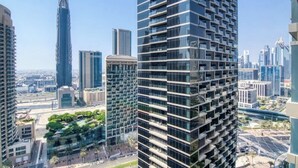 Un edificio de gran altura con un diseño arquitectónico moderno, que cuenta con varios balcones y fachada de vidrio.