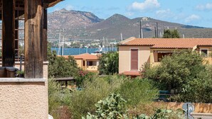 A coastal view with buildings, a mountain, and boats. - Raggio di sole Olbia (Olbia)