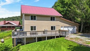 A two-story house with a red roof, a balcony with railings, and a garage.