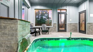 A pool area with a stone wall, a bench, and a door. - Perfect Family Retreat MTN Views Pool Privacy (Sevierville)