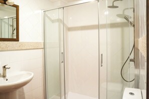 Habitación superior con 2 camas individuales | Baño | Regadera, jabón, shampoo, papel de baño