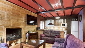 A living room with a fireplace, sofa, and coffee table. - Rural House 'Fuente Los Avellanos' with Mountain View, Wi-Fi and Air Conditioning (Villanueva del Arzobispo)
