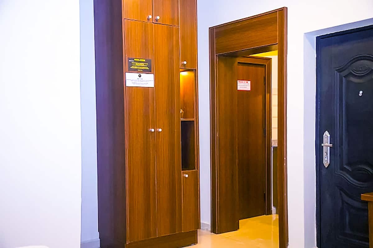A hallway with wooden doors, one of which has a sign.
