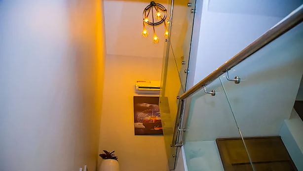 Eine Treppe mit Glastrennwand, einem Blumentopf und einem Wandbild.