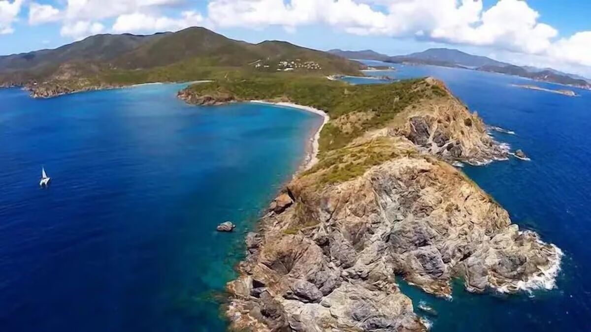 A coastal landscape with rocky terrain and clear blue waters.