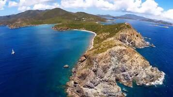A coastal landscape with rocky terrain and clear blue waters.