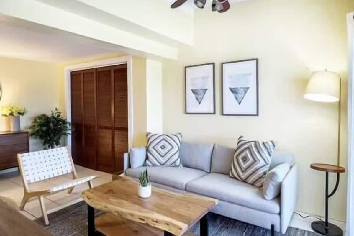 A living room with a sofa, a coffee table, a chair, and a floor lamp.