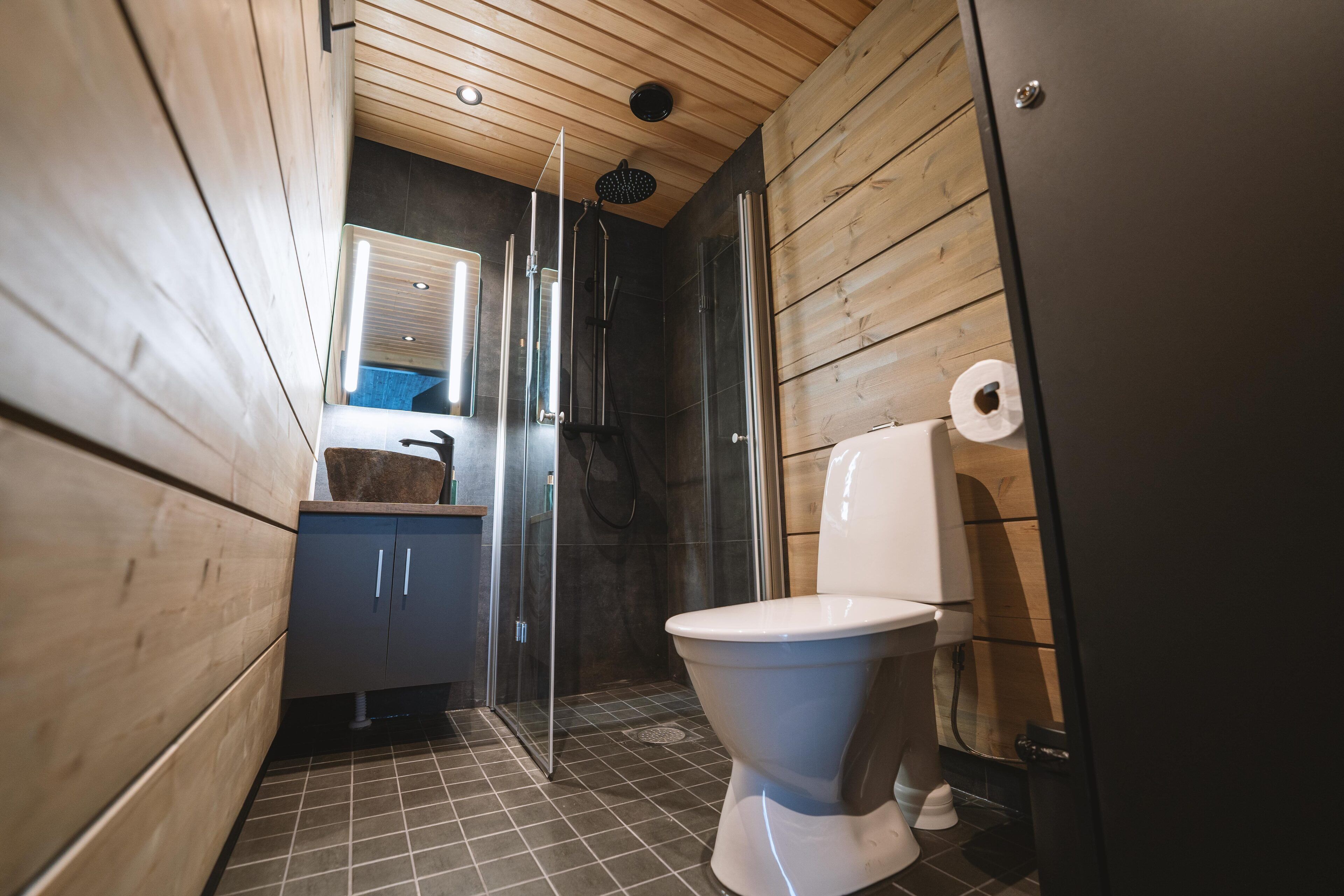 A compact bathroom with a shower, toilet, and a small sink area.