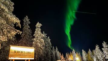 Aurora Hill Resort -kyltti, josta avautuu näkymä revontuliin.