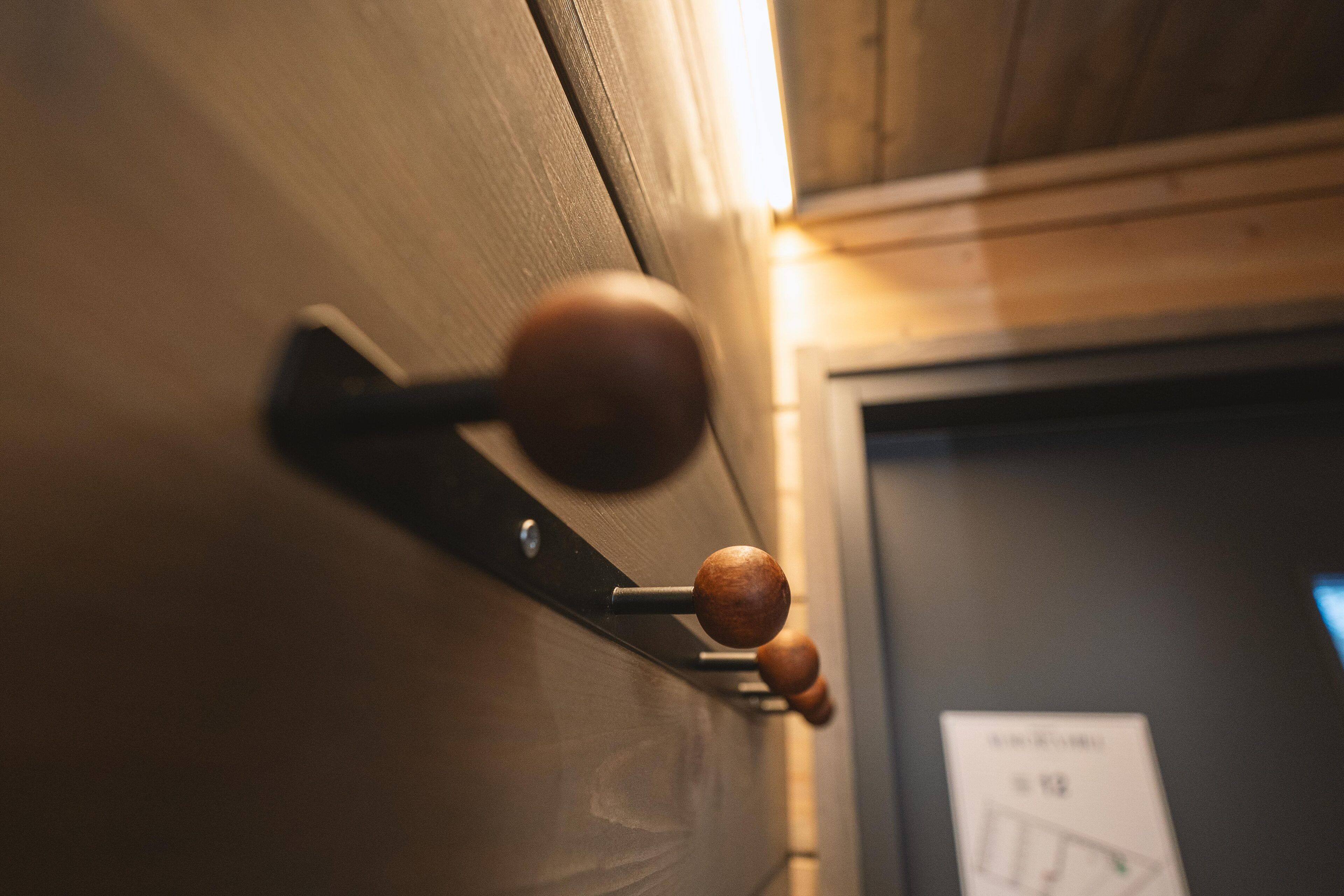 A close-up of a wooden door handle with a metal latch.