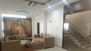 Ein modernes Wohnzimmer mit Buddha-Statue, Sofa und Couchtisch.