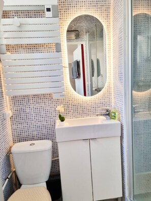 Ein Badezimmer mit Toilette, Waschbecken und Duschbereich.