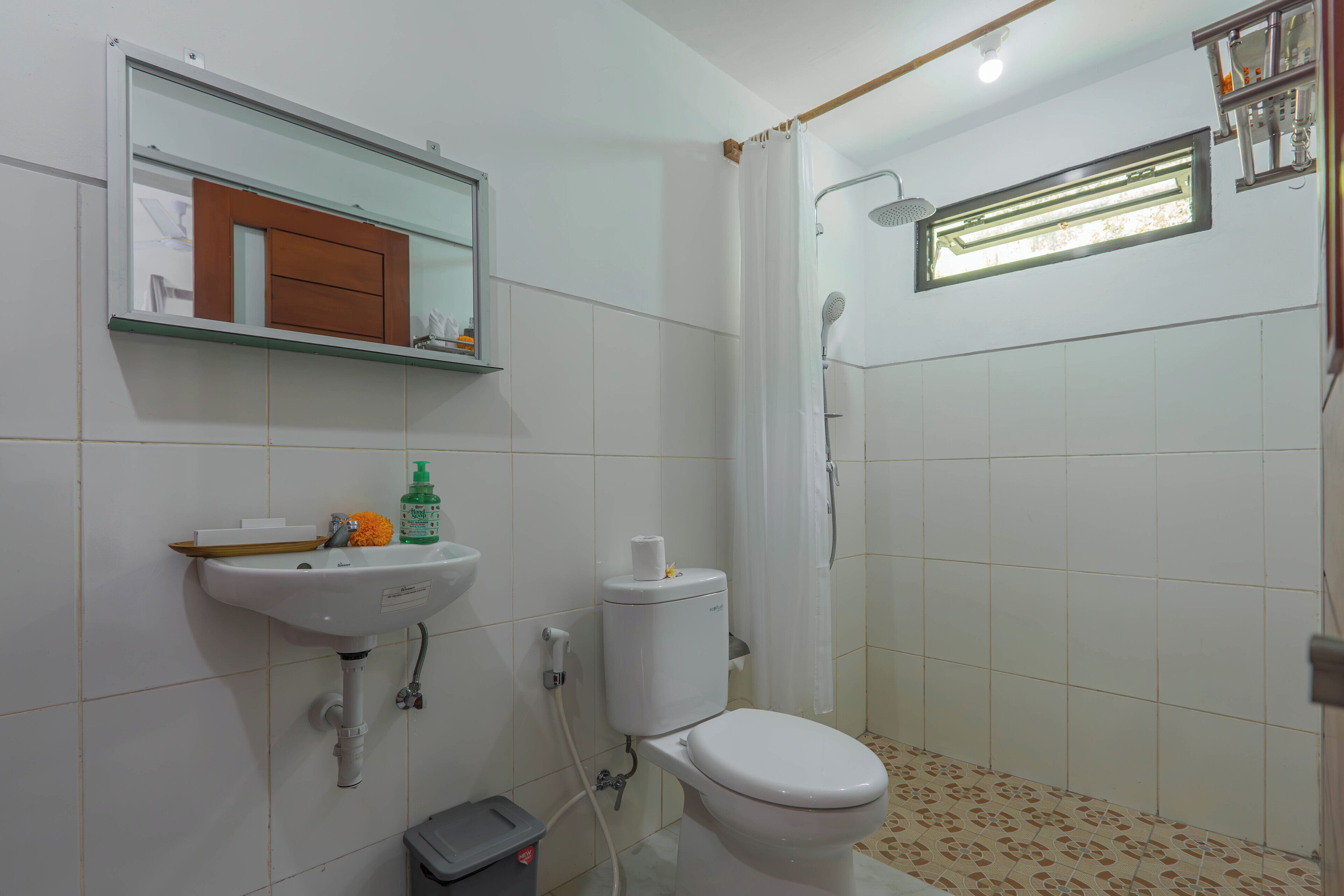 A bathroom with a toilet, sink, and shower.