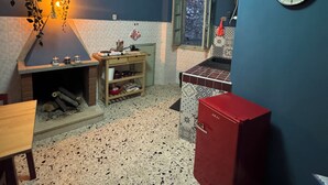 A compact kitchen with a built-in stove, a hanging plant, and a clock on the wall. - Historic & Charming Home in Bassiano (Bassiano)
