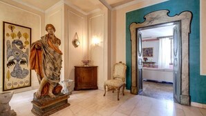 A stately room with a marble floor, a classical statue, a wooden cabinet, and a chair. - Spacious 5-bedroom apartment in charming Firenze with AC (Firenze)