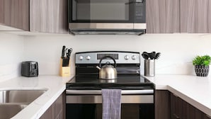 A kitchen with a microwave, stove, and sink.