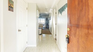 A hallway with white doors, a wooden door, and a sign that reads "LIVE LOVE FISH". - Lakefront Condo in Clewiston •Heated Pool•Fishing Paradise •Sleeps 4 (Clewiston)