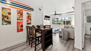 Un espacio habitable moderno con comedor, sofá y obras de arte en las paredes.