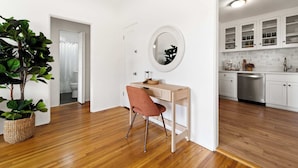 Una cocina moderna con armarios blancos, encimera de madera y lavavajillas integrado.
