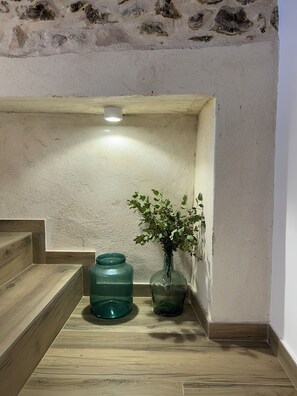 A corner with a wooden staircase, a green water dispenser, and a vase with green leaves. - We've just opened! New country house in Almatret, perfect for unwinding (Almatret)