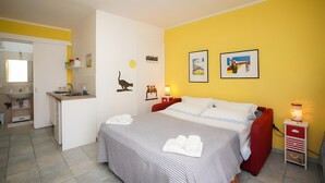 Un dormitorio con cama, mesitas de noche, escritorio y baño.