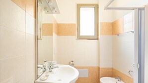 A bathroom with a sink, mirror, window, and toilet. - Room 'Arancio' with Lake View, Wi-Fi and Air Conditioning (Otranto)