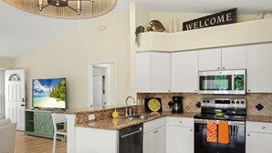 A modern kitchen with white cabinets, a granite countertop, a built-in oven, and a microwave. - ☀️Private Pool | Pet Friendly | Close to Beach | Citrus Sol☀️ (Fort Myers Beach)