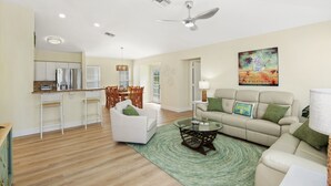 A spacious living area with a dining table, white sofas, and a coffee table. - ☀️Private Pool | Pet Friendly | Close to Beach | Citrus Sol☀️ (Fort Myers Beach)