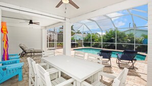 A covered outdoor area with a pool, white furniture, and a ceiling fan. - ☀️Private Pool | Pet Friendly | Close to Beach | Citrus Sol☀️ (Fort Myers Beach)