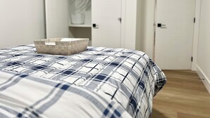 Un dormitorio con cama, cómoda y armario.