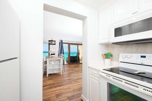 Una cocina moderna con armarios blancos, horno integrado y vistas al exterior.