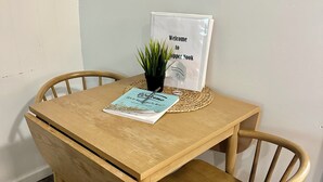 A wooden dining table with a placemat, a small potted plant, and a welcome sign. - 1-bedroom house in charming Calumet (Calumet)