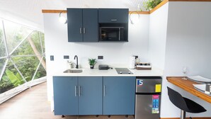 Une cuisine moderne avec des meubles bleus, un four à micro-ondes, un évier et un réfrigérateur.