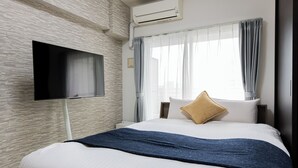 A modern hotel room with a large bed, a flat-screen TV mounted on the wall, and a window with curtains. -  SPAZIO 2 Canal Hakata (Fukuoka)