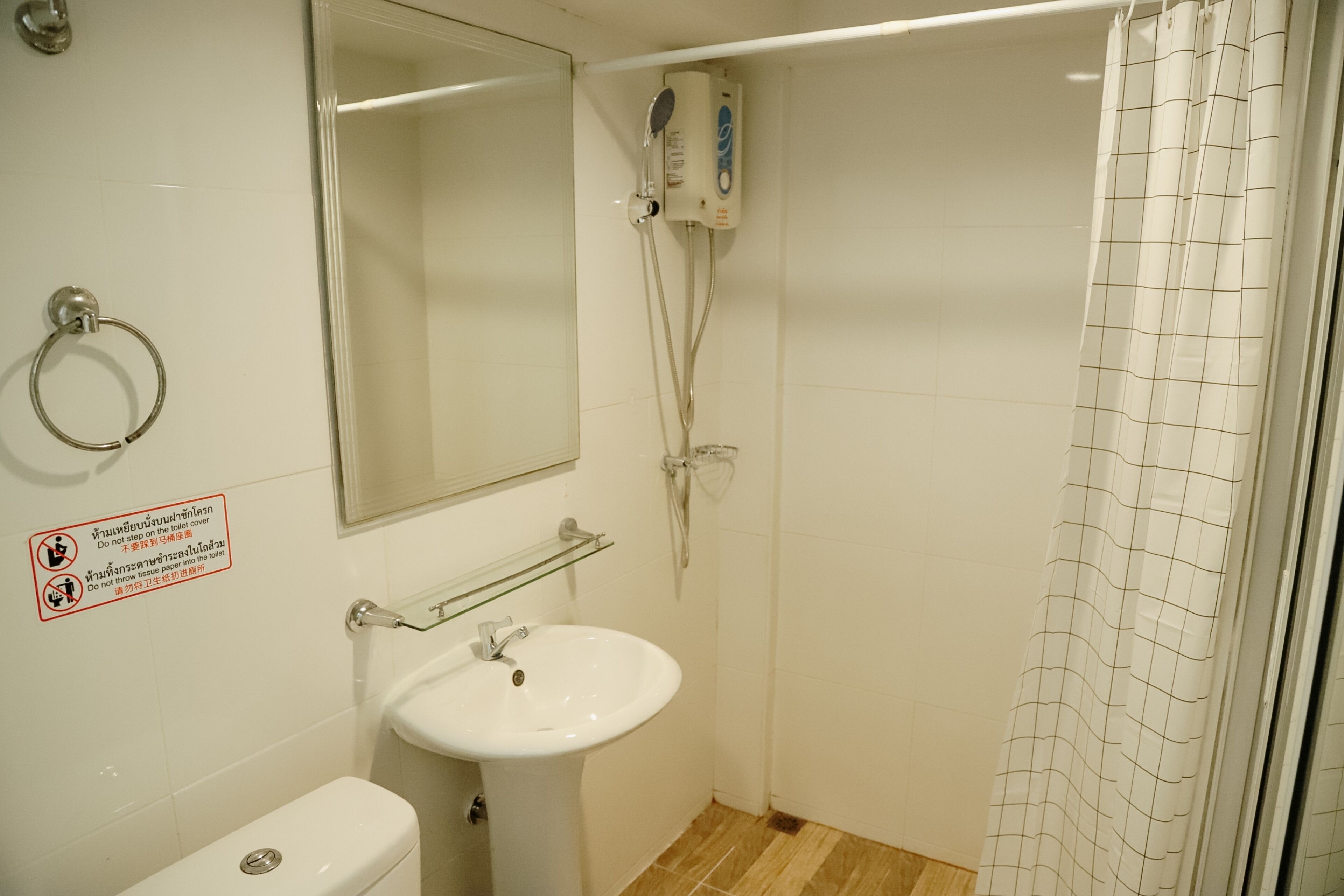 A bathroom with a toilet, sink, and shower.