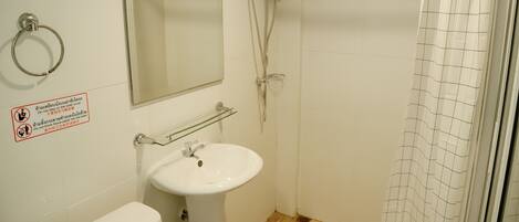 A bathroom with a toilet, sink, and shower.