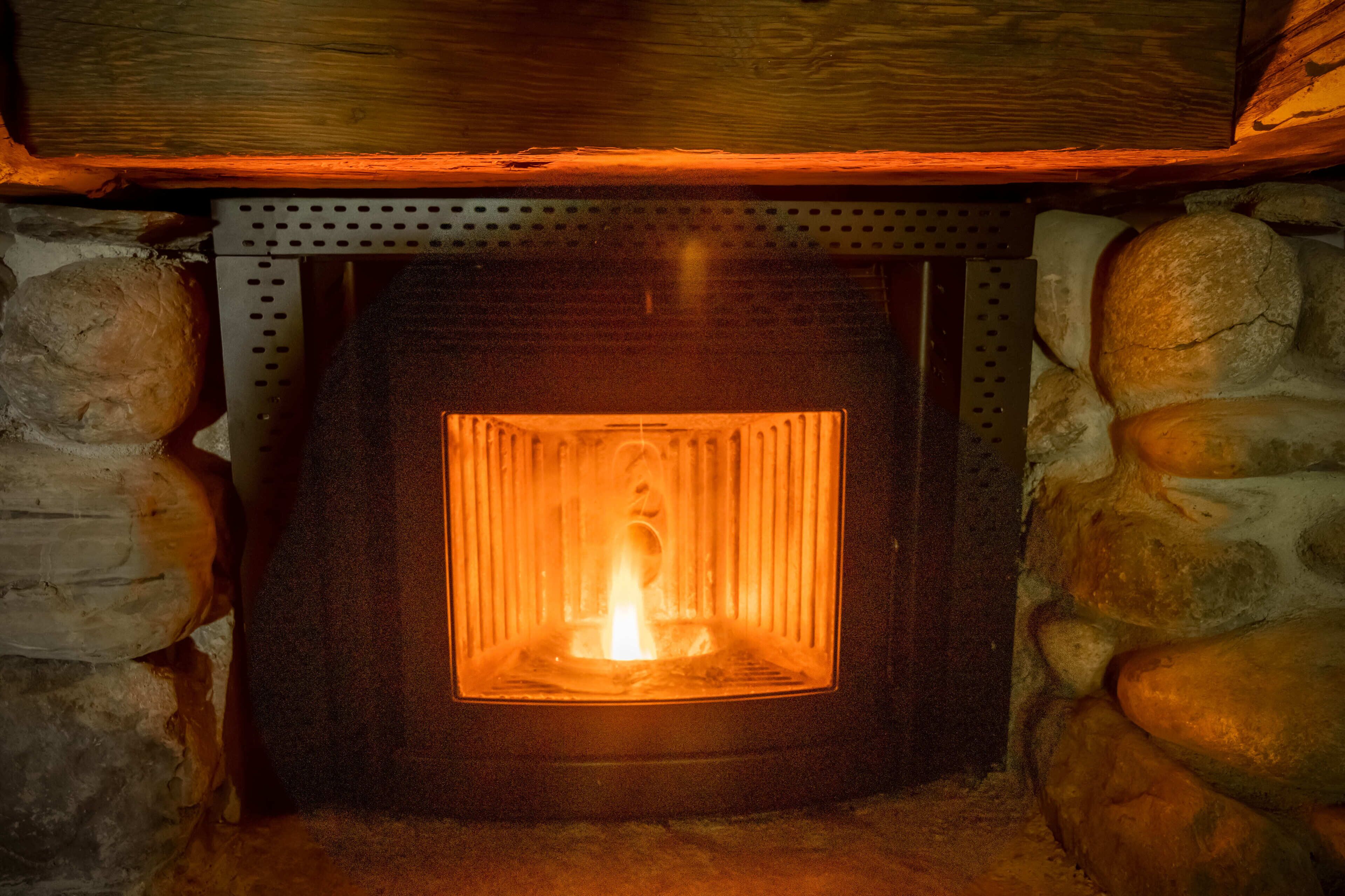 Ein Steinkamin mit Holzschmuck und einem Metallrost.