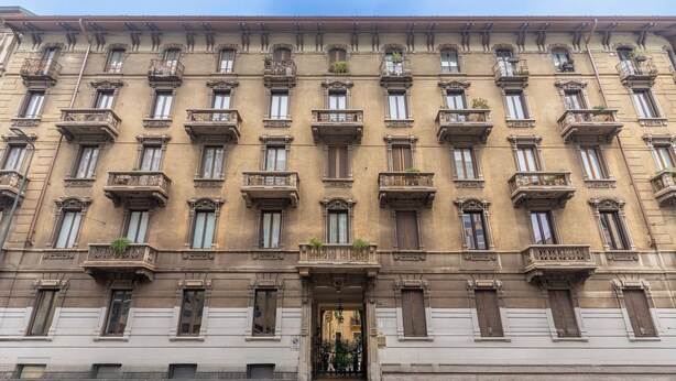 Un bâtiment historique doté de nombreux balcons, de grandes fenêtres et d’une entrée centrale.