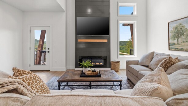 Una sala de estar moderna con chimenea, un sofá, una mesa de centro y un televisor montado en la pared.