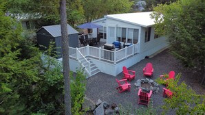 Een chalet met een terras, buitenmeubelen en een barbecueplaats.