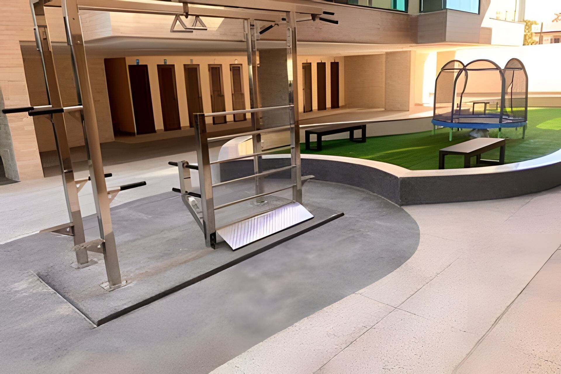 A gym with a pull-up bar, benches, and a small outdoor area with artificial grass.