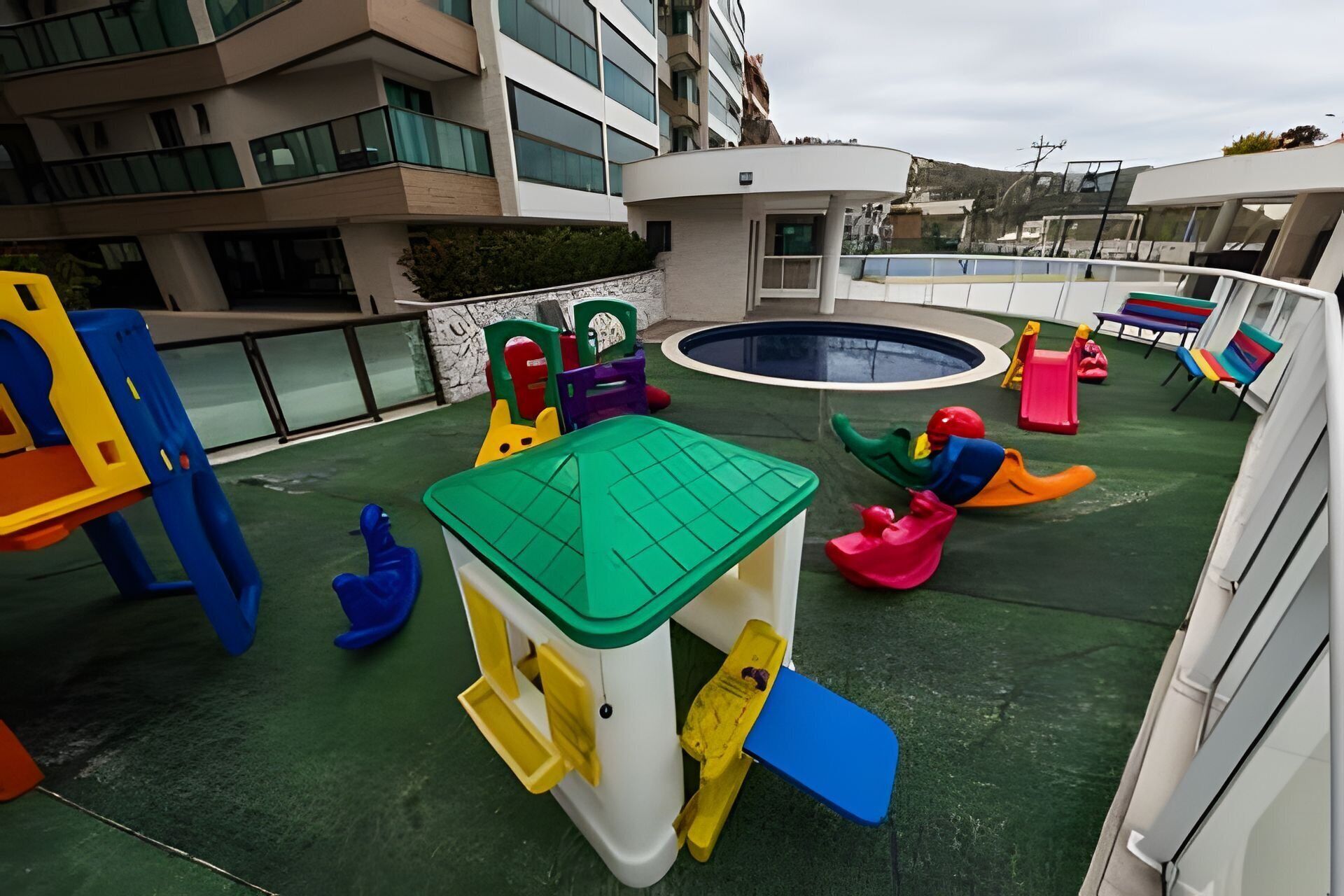 Un espace de jeux pour enfants avec une piscine, des toboggans et une petite table.