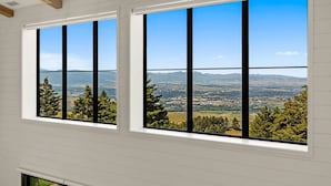 A room with large windows offering a view of a valley and distant mountains. - Resolute Ridge: Peak Lodge (Bozeman)