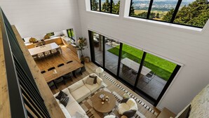 Un intérieur moderne comprenant un coin repas, des sièges et une grande fenêtre donnant sur une pelouse verdoyante.