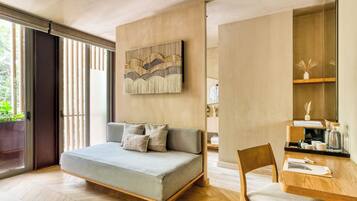 A modern room with a sofa, a wooden table, and a wall-mounted artwork.