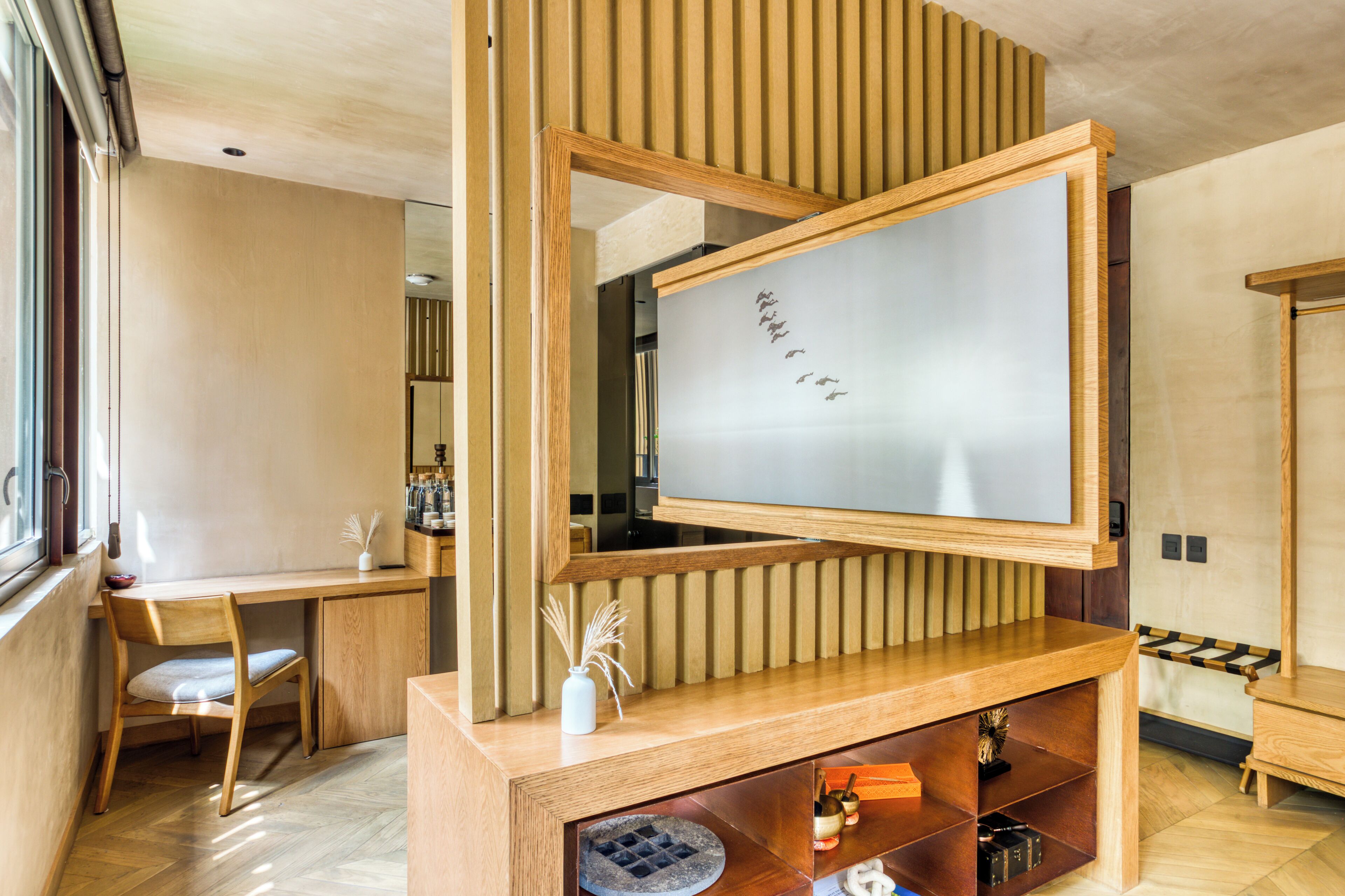 A modern room with a wooden desk, a whiteboard, and a bookshelf.