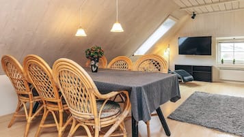 Een eethoek met een tafel, stoelen en een televisie.