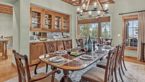 A spacious dining area with a long wooden table set for a meal, surrounded by wooden chairs. - Luxury Ski-in/out Retreat | Timber Haven (Avon)
